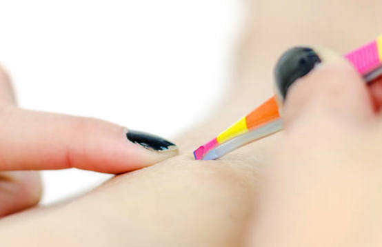 女孩用镊子拔头发从他们的腿